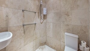 Un bagno con doccia, WC e lavandino.