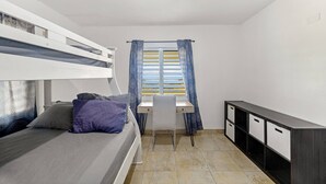A dormitory room with bunk beds, a desk, a chair, and a wardrobe. - Hilltop Getaway With Huge Terrace (Fajardo)