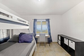 A dormitory room with bunk beds, a desk, a chair, and a wardrobe. - Hilltop Getaway With Huge Terrace (Fajardo)