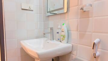 Une salle de bain avec un lavabo blanc, un miroir et un savon Dove.