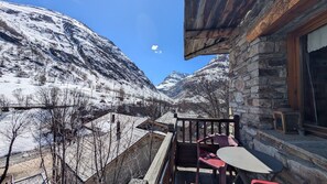 Ein Berggrundstück mit Balkon mit Blick auf ein verschneites Tal.