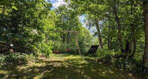 Ein Garten mit Schaukel und Stuhl.