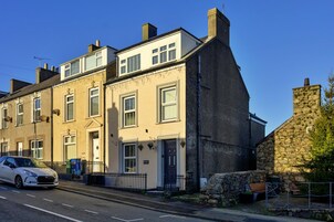 A two-story building with a stone facade, a white upper floor, and a black lower floor.