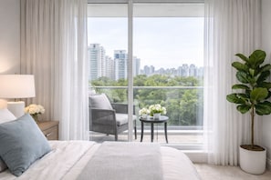 A bedroom with a bed, a nightstand, a lamp, a chair, a small table with flowers, and a potted plant. - Spacious 2BR Apartment in Central Toronto (Toronto)