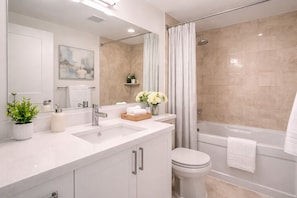 A modern bathroom with a large sink, a toilet, and a bathtub. - Spacious 2BR Apartment in Central Toronto (Toronto)