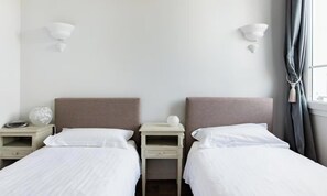 A hotel room with two single beds, bedside tables, and wall-mounted lamps. - A PERFECT BLEND OF LUXURY WITH BREATHTAKING 360° VIEWS MEDITERRANEAN SEA (Cannes)
