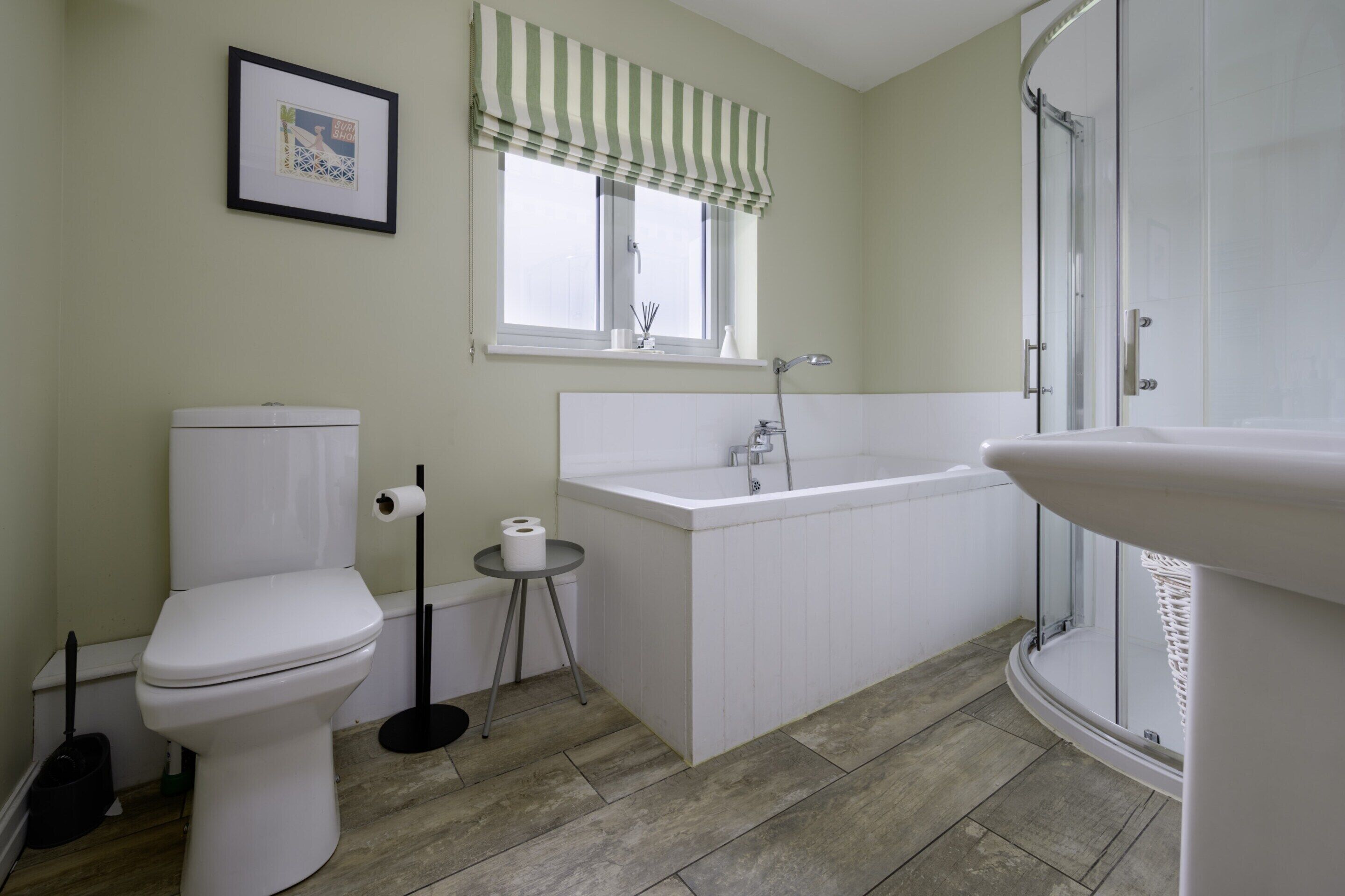 A bathroom with a toilet, a bidet, a bathtub, and a shower.