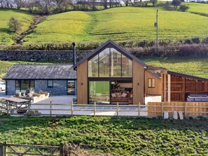 A modern house with a large glass front, a stone exterior, and a wooden deck. - Luxury Lodge With Swim Spa for 8 (Bala)