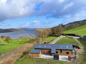 A rural property with a large building, a fenced area, and a view of a lake and hills. - Luxury Lodge With Swim Spa for 8 (Bala)