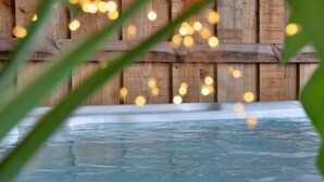 A hot tub with a wooden fence in the background. - Luxury Lodge With Swim Spa for 8 (Bala)