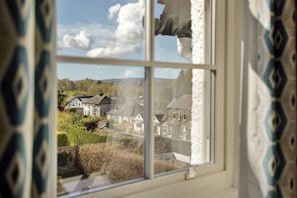 A window view of a residential area with houses and greenery. - Charming Snowdonia Cottage for 4 (Ambleside)