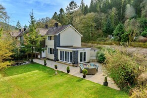 A modern two-story house with a large patio area, a swimming pool, and a well-maintained lawn. - Luxury Country Estate Near Largs (Betws-Y-Coed)