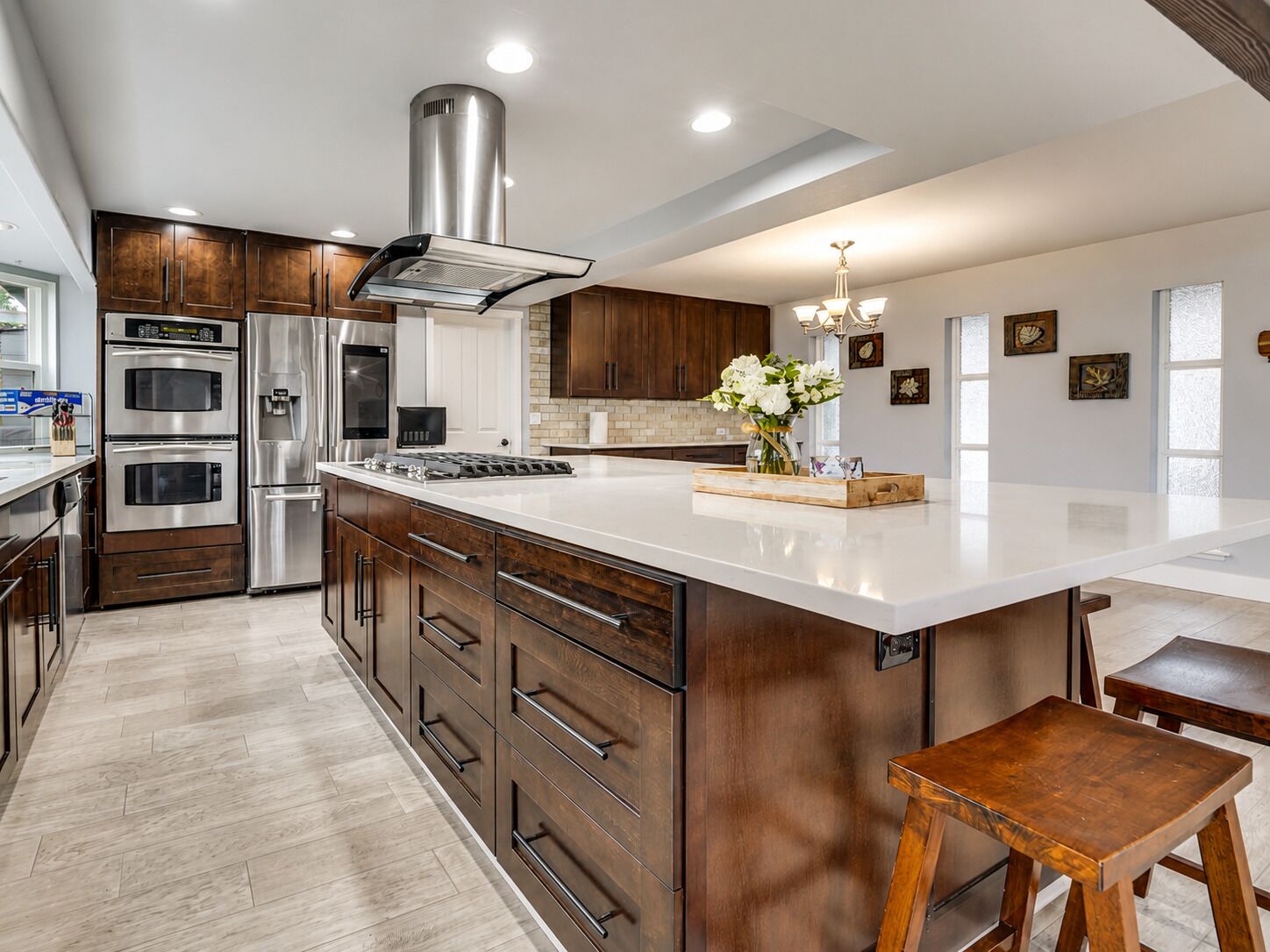 A modern kitchen with stainless steel appliances, wooden cabinetry, and a large island.