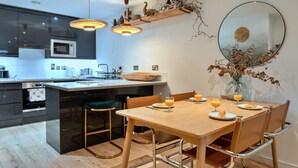 Una cocina moderna con una isla central, electrodomésticos de acero inoxidable e iluminaci ón colgante.