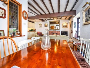 A dining area with a wooden table, chairs, and a fireplace. - 2-bedroom Seaside Home (Whitby)