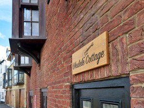 A wooden sign on a brick building with the text 'Ukulele Cottage.' - 2-bedroom Seaside Home (Whitby)