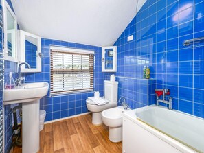 A bathroom with blue tiles, a white sink, a toilet, a bidet, and a bathtub. - 2-bedroom Seaside Home (Whitby)
