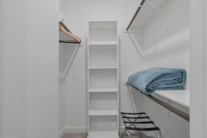 A walk-in closet with white shelving units and a metal drying rack. - Sleeps 14, GameRoom + Sports + Grill, Near Reliant Stadium (Houston)