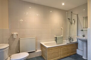 Un baño con inodoro, bañera, ducha y lavamanos.