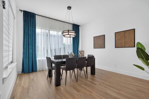 A dining area with a table, chairs, and a hanging light fixture. - Luxe 3BR/3.5BA Garage. Patio. Near UTSW & DT (Dallas)