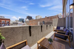 A rooftop terrace with a view of the city skyline, featuring a mix of modern and historic buildings. - Explore Gaslamp from Chic Loft +Balcony City Views (San Diego)