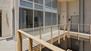 A modern building with large windows, a metal railing, and an exit sign. - Explore Gaslamp from Chic Loft +Balcony City Views (San Diego)