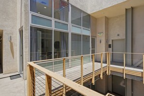 A modern building with large windows, a metal railing, and an exit sign. - Explore Gaslamp from Chic Loft +Balcony City Views (San Diego)
