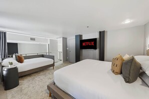 A hotel room with a bed, a bedside table, a TV, and a wardrobe. - Explore Gaslamp from Chic Loft +Balcony City Views (San Diego)