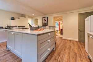 Una cocina con una isla central, suelo de madera y vistas al área de comedor.