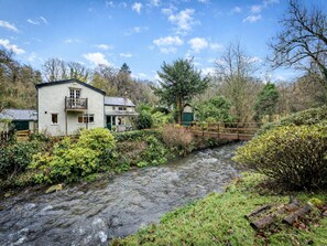 A river flowing through a rural area with a house and a small bridge. - Spacious Cottage Near Denbigh (Denbigh)
