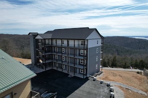A multi-story building with a covered parking area and a view of the surrounding landscape. - BWV 241 Pam's Place (Branson)