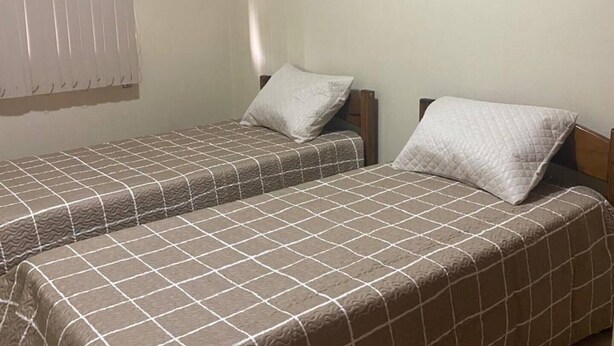 Habitación con dos camas individuales, cada una con almohada y cabecero.
