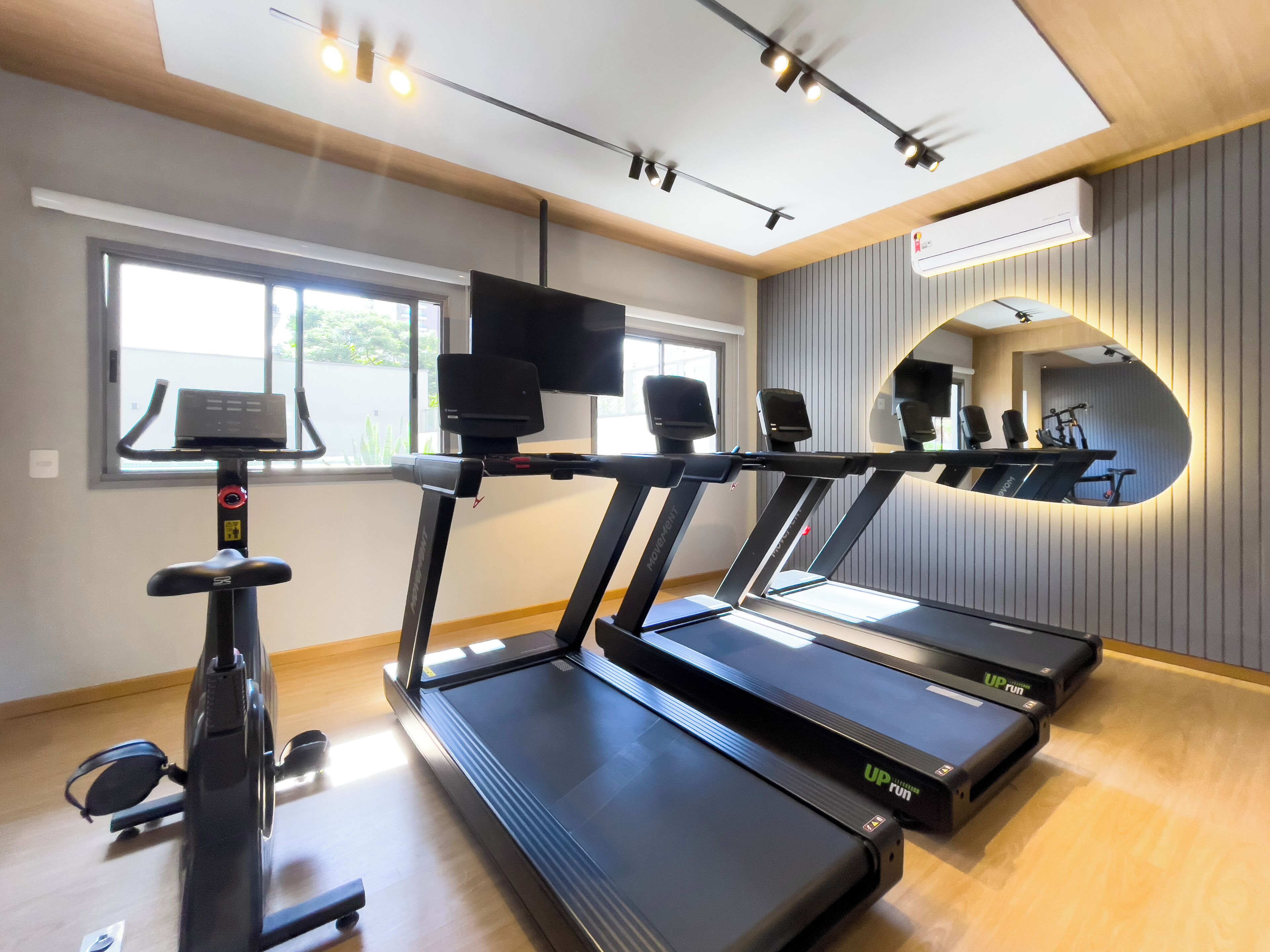 Ein Fitnessraum mit Laufbändern, einem Ergometer und einem Rudergerät.
