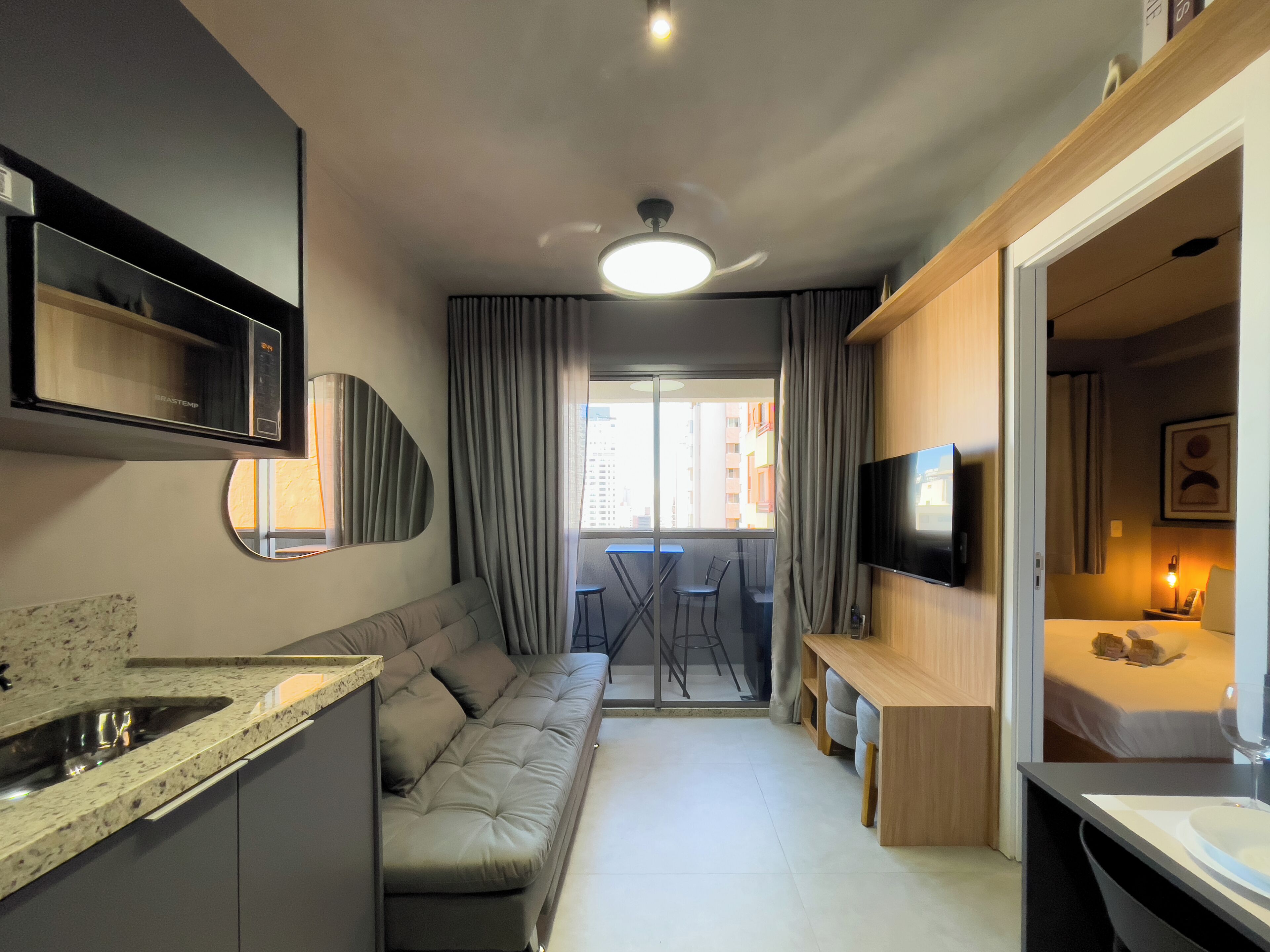 Ein gemütliches Hotelzimmer mit Küchenzeile, einer Sitzecke, einem Essbereich und einem Bett.
