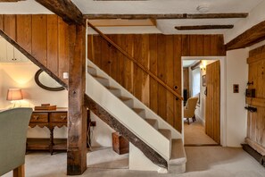 Eine Holztreppe mit Handlauf, die zu einer zweiten Etage führt.