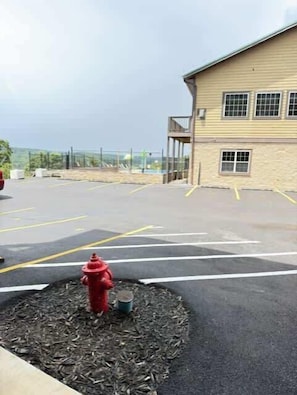 A parking lot with a red fire hydrant, a building with windows, and a clear sky. - Nanna's Nook NEW Heated Indoor Pool Splashpad SDC (Branson)