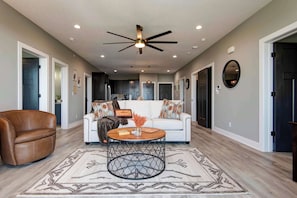 A spacious living room with a ceiling fan, a coffee table, and a sofa. - Nanna's Nook NEW Heated Indoor Pool Splashpad SDC (Branson)