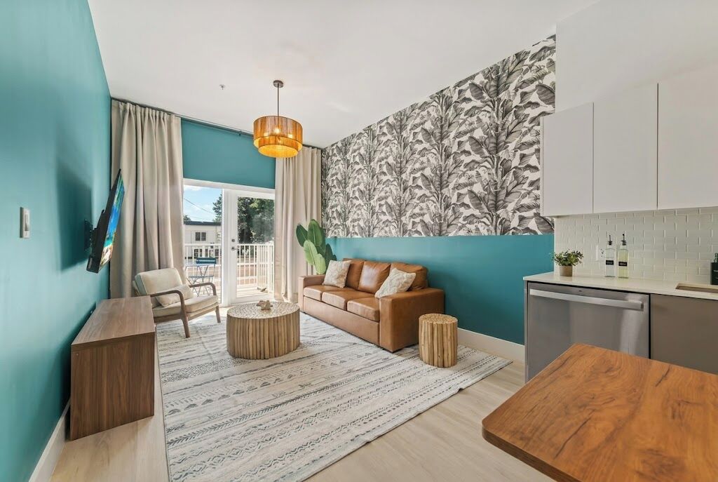 A modern living space with a sofa, coffee table, and a dining table.