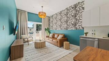 A modern living space with a sofa, coffee table, and a dining table.