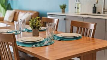 A dining table set with plates, glasses, and a small plant.