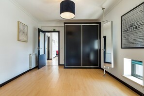 A hallway with a wooden floor, a black door, and a wall-mounted light fixture. - Luxurious Retreat in Lousã Countryside (Lagarteira)