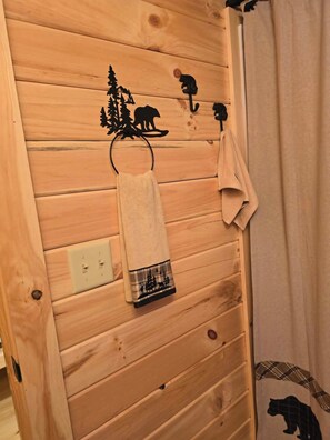 Eine Holzwand mit einem Handtuchhalter, der ein Handtuch und eine Dekoration trägt.
