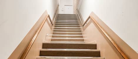 Un escalier avec des rampes en bois et un mur de couleur claire.