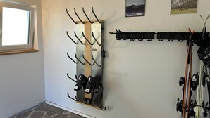 Huone, jossa on seinälle kiinnitetty suksiteline ja peili.
