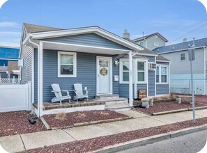 A single-story house with a front porch, a mailbox, and a small garden area. - Seaside Cottage - a guest favorite since 2021! (Seaside Heights)