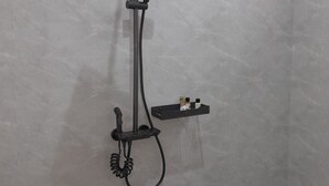 A modern shower with a handheld showerhead, a fixed showerhead, and a handheld shower attachment. - IGAWILO RESIDENCE HOTEL (Dodoma)