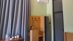 A room with a bed, a wardrobe, a mirror, and a window with curtains. - IGAWILO RESIDENCE HOTEL (Dodoma)