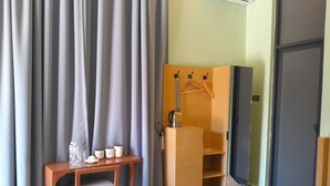 A hotel room with a wooden desk, a chair, a wardrobe, and a bed. - IGAWILO RESIDENCE HOTEL (Dodoma)