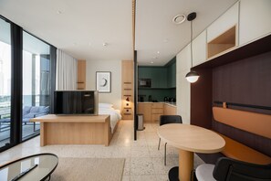 A modern hotel room with a large bed, a TV, a desk, a dining area, and a view of the city. - Sleek Studio w/ Burj Khalifa View (Dubai)