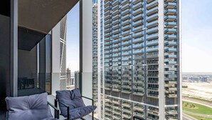 Ein Balkon mit moderner Einrichtung und Blick auf hohe Gebäude.